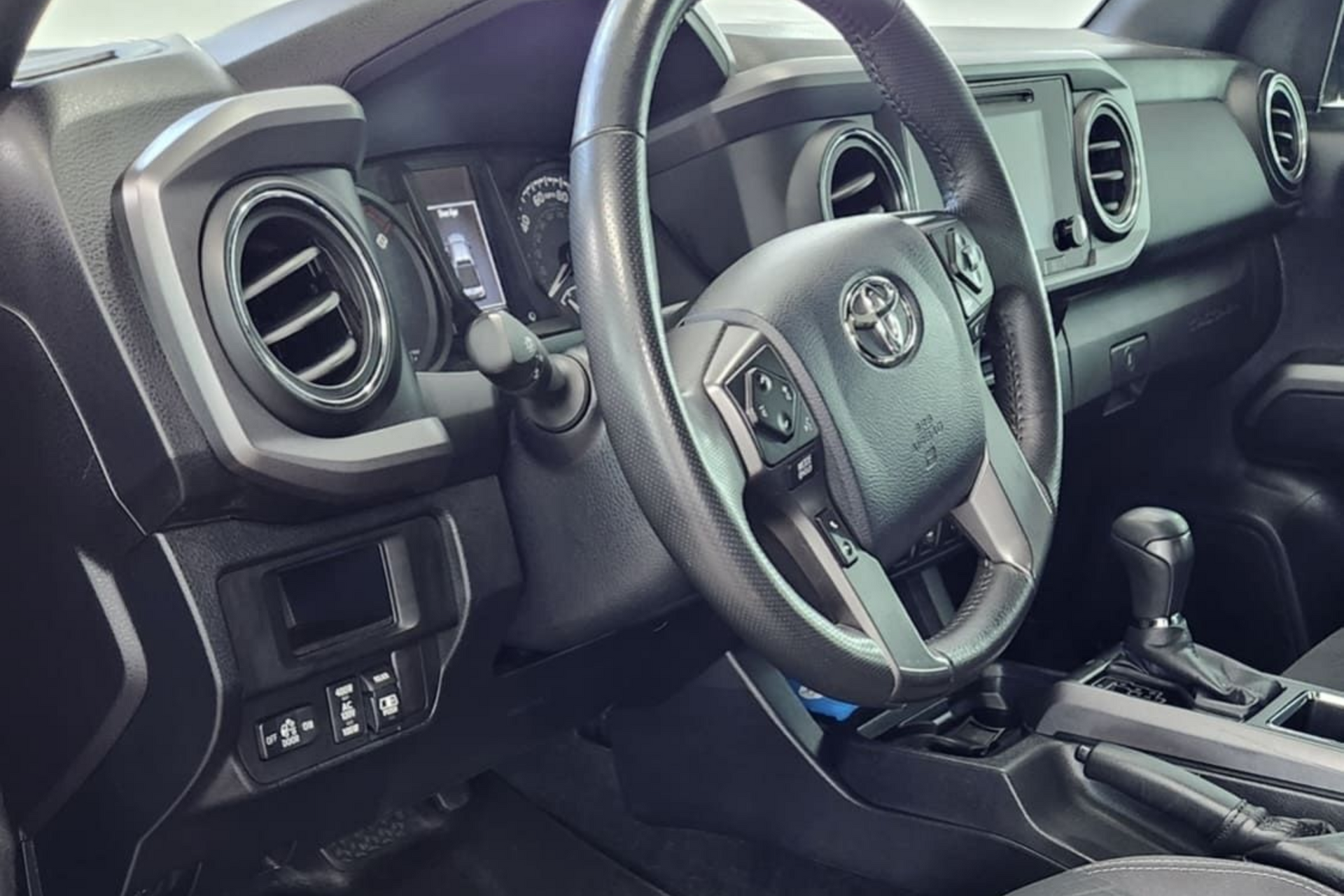 Red and white Ford Bronco parked on a residential street with trees.