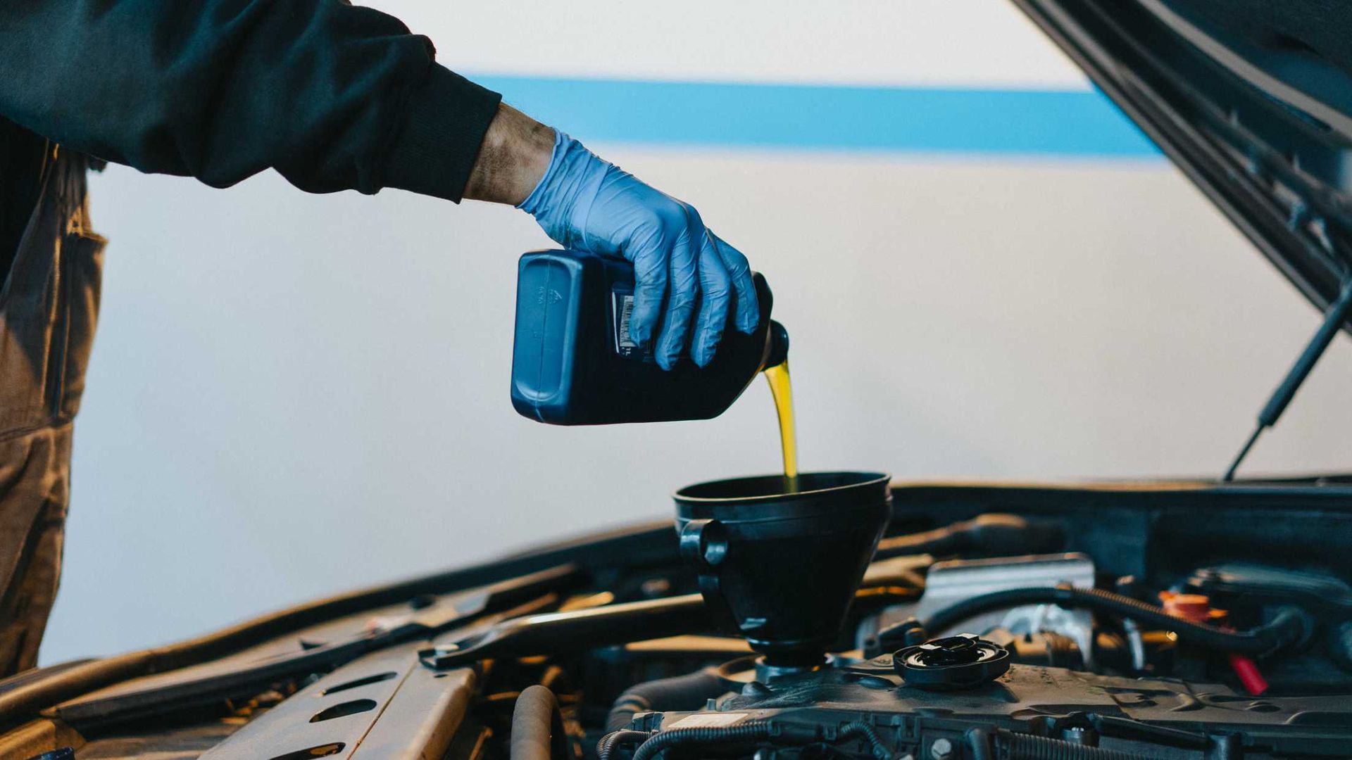 oil being poured into car by a mechanic