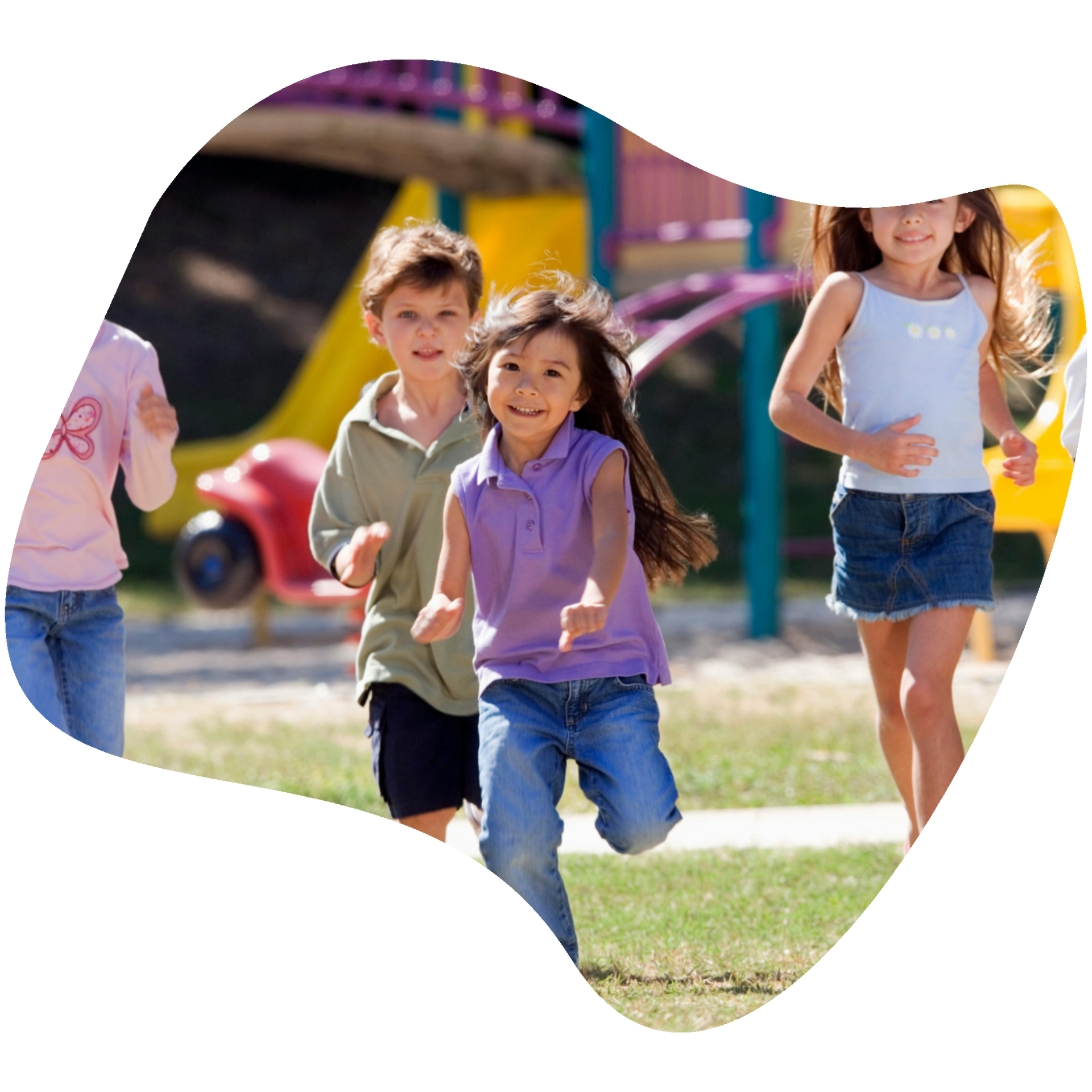 Children playing on a playground, running and smiling. A yellow slide is in the background.