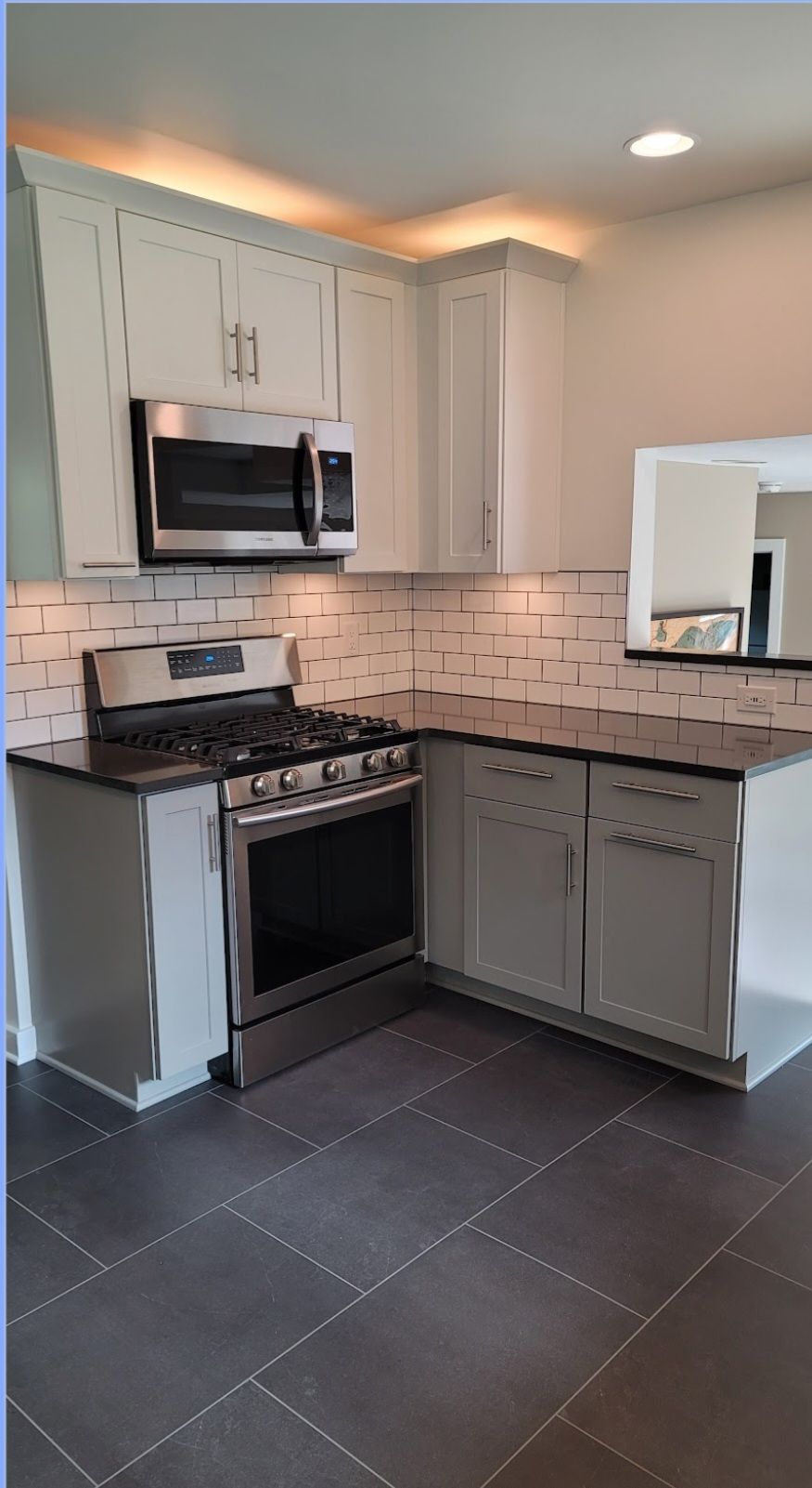 A kitchen with stainless steel appliances and white cabinets.