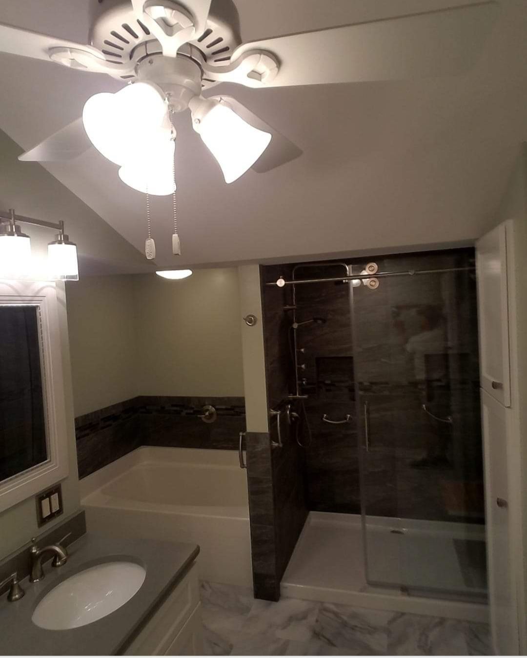 A bathroom with a sink and a ceiling fan