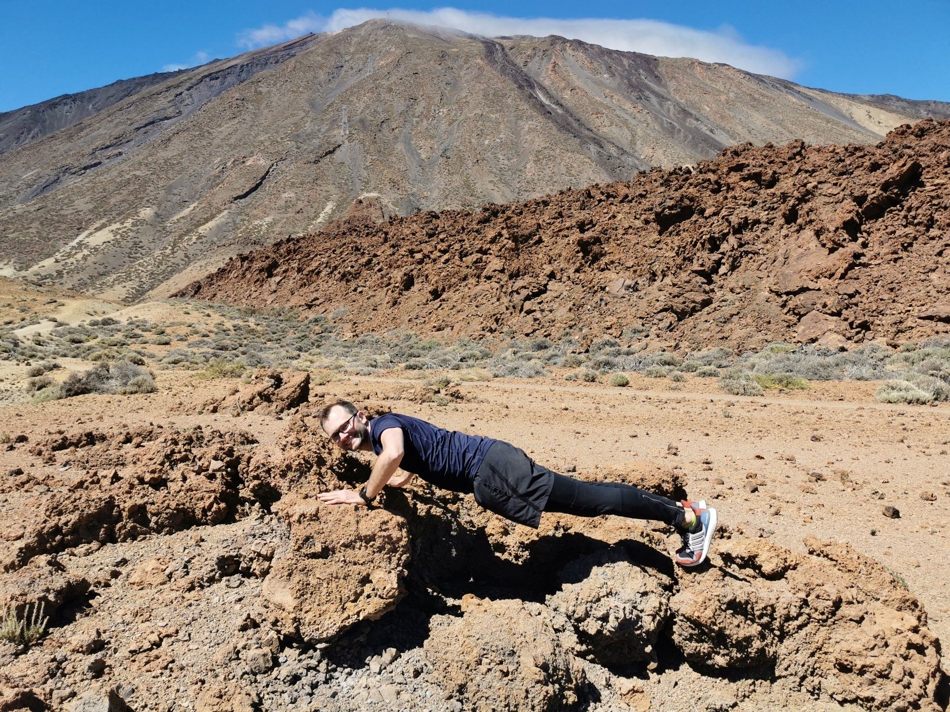 Liegestütz auf Vulkangestein vor dem Vulkan El Teide auf Teneriffa