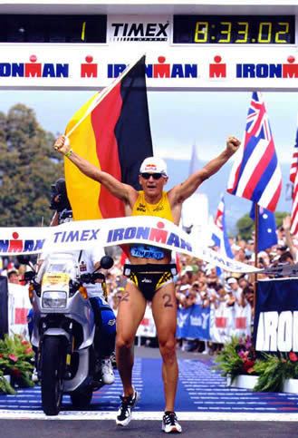 Thomas Hellriegel überquert eine Ziellinie mit Deutschland Flagge in der Hand