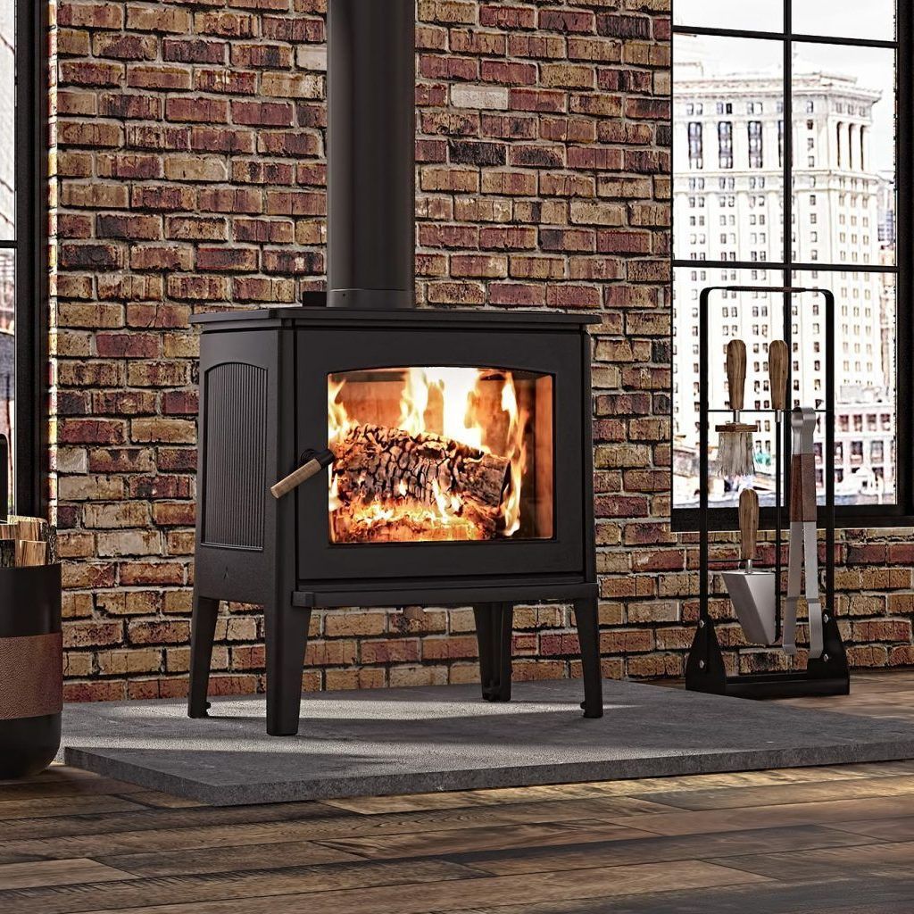 A wood stove is sitting in front of a brick wall in a living room.