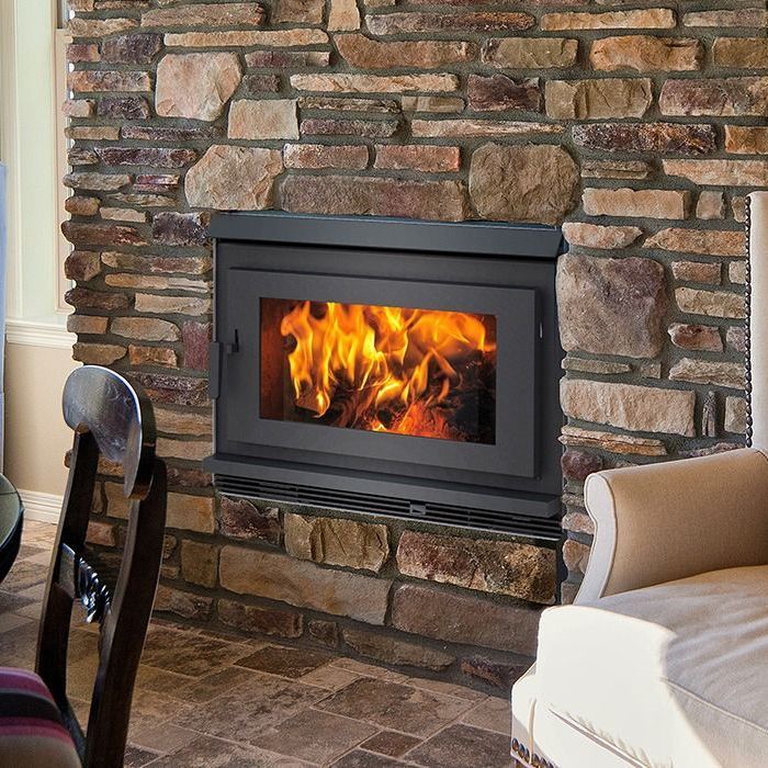 A fireplace built into a stone wall in a living room