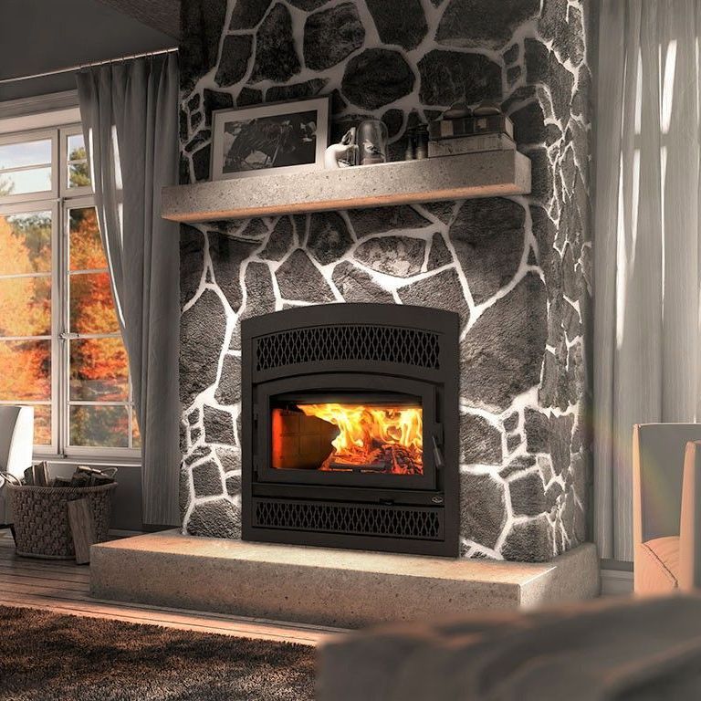A living room with a fireplace and a stone wall