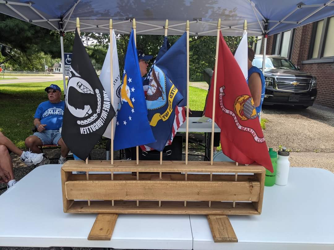 A bunch of flags are sitting on a table under a tent