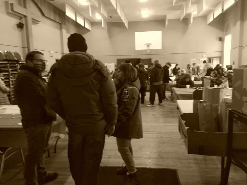 A group of people are standing in a room talking to each other