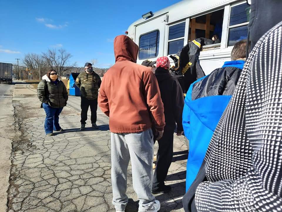 A group of people standing in front of a bus
