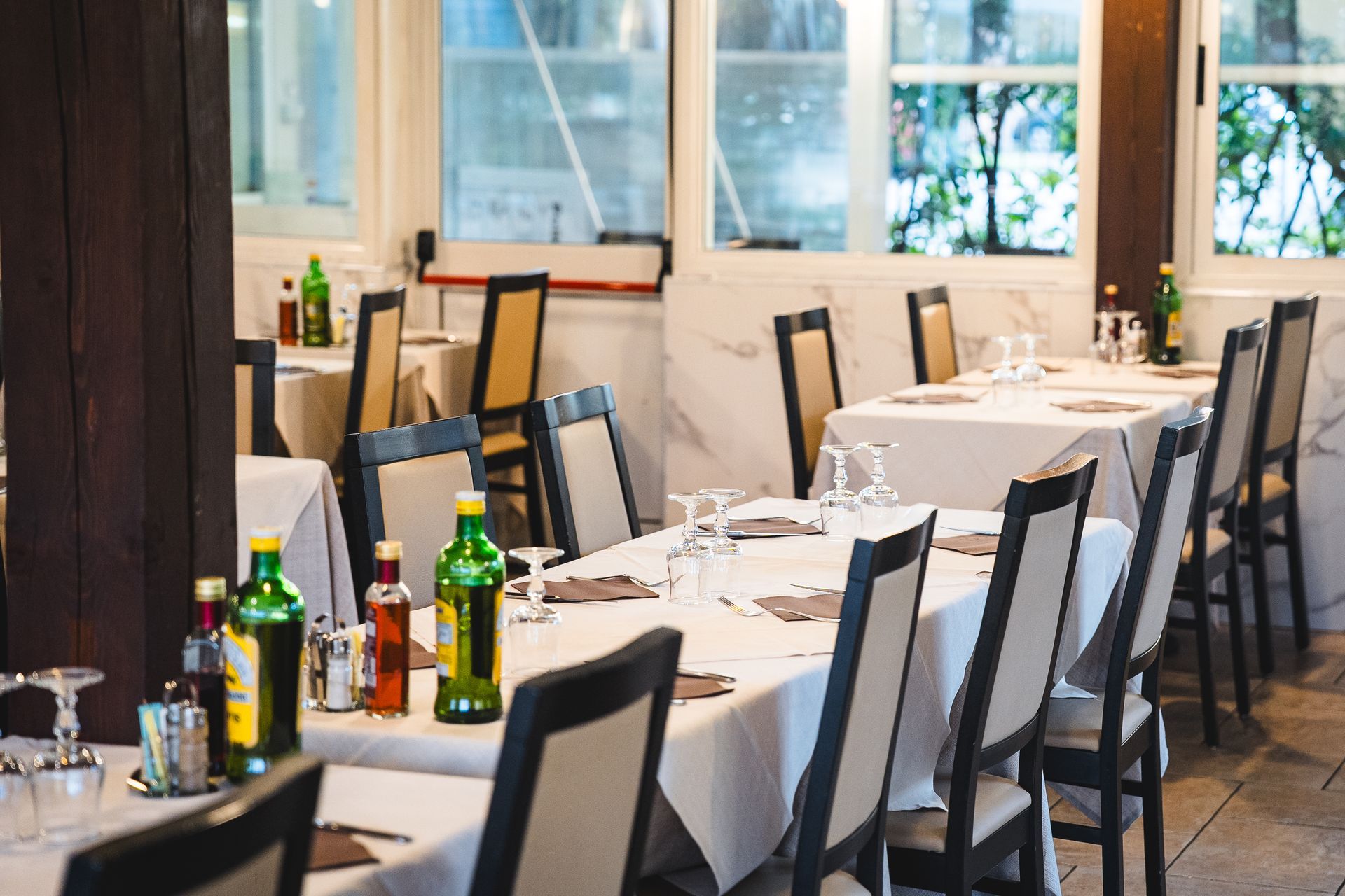 Sala da pranzo del ristorante con tavoli apparecchiati per gli ospiti, luce del sole che filtra dalle finestre.