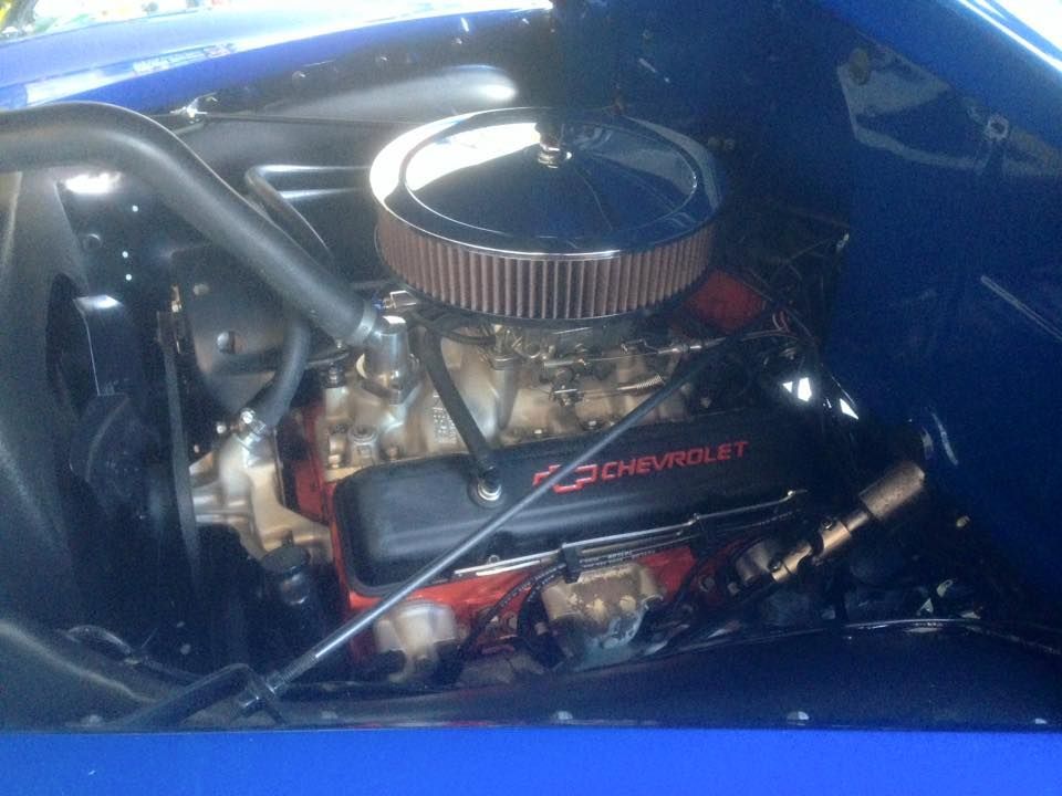 Blue car engine bay with a Chevrolet engine, chrome air filter, and black accents.