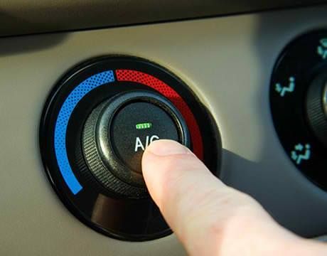 Dirty, clogged air filter removed from a vehicle, filled with leaves, dirt, and debris.