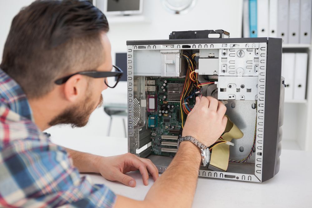 Man With Glasses Repairs a Desktop Computer, Inspecting Internal Components — Tech Aid In Moffat Beach, QLD