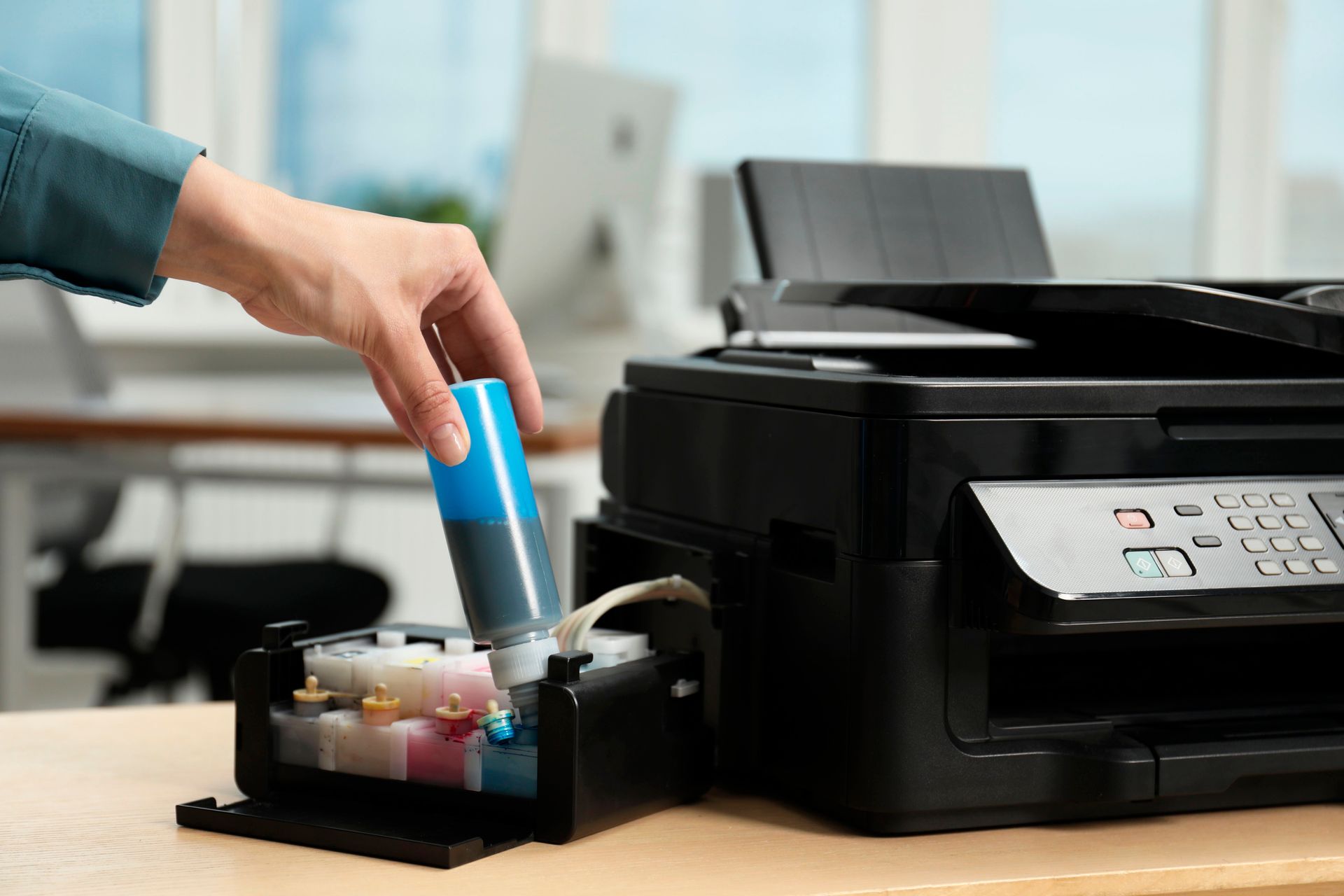 Person Inserting a Blue Ink Cartridge Into a Black Printer in an Office — Tech Aid In Moffat Beach, QLD