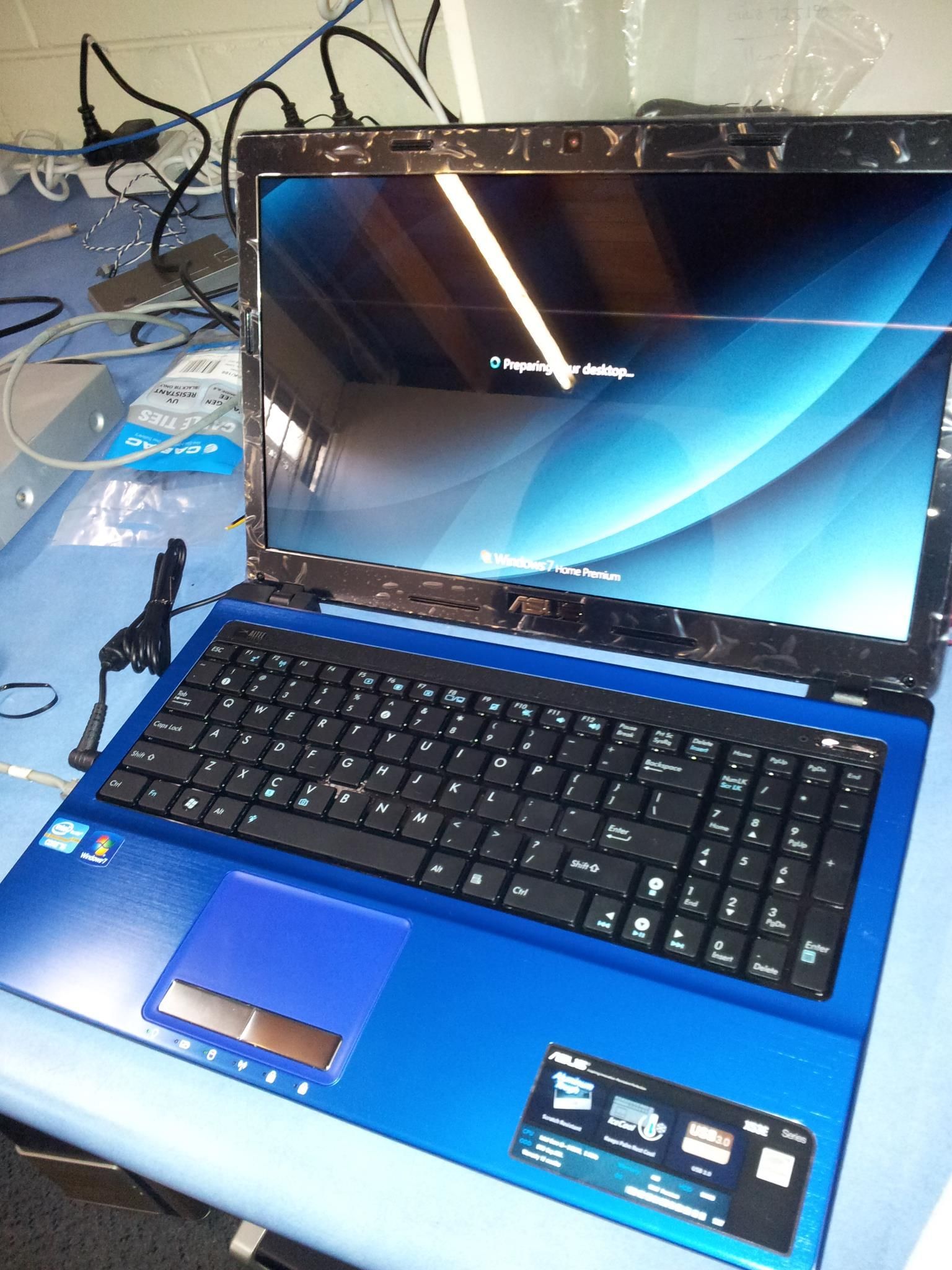 Blue Laptop on a Table With a Lit-up Screen Displaying a Blue and White Background — Tech Aid In Sunshine Coast, QLD