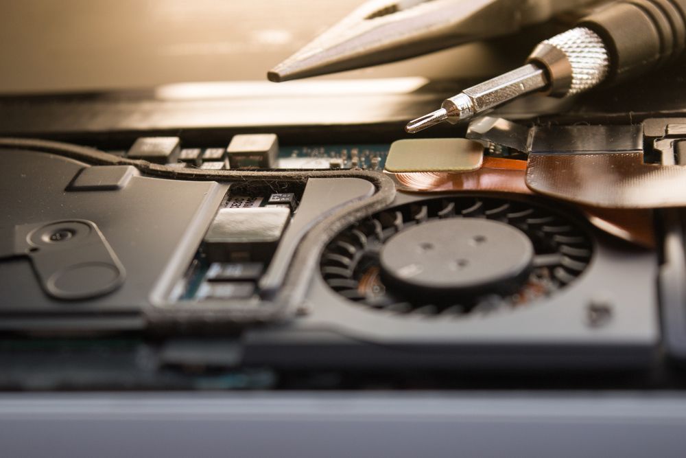 Close-up of Laptop Components With a Screwdriver Disassembling a Cooling Fan — Tech Aid In Moffat Beach, QLD