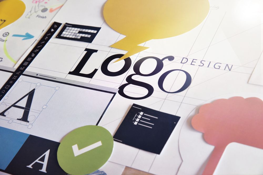 Logo Design Process With Paper Cutouts, Sketches, and Tools on a Light Surface — Tech Aid In Moffat Beach, QLD