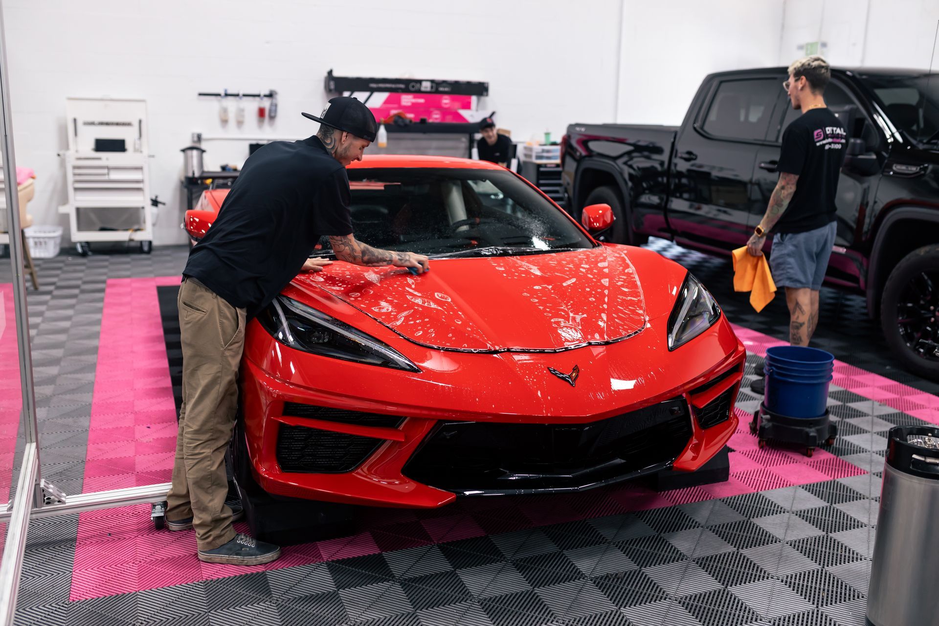 A red sports car is driving down a city street.