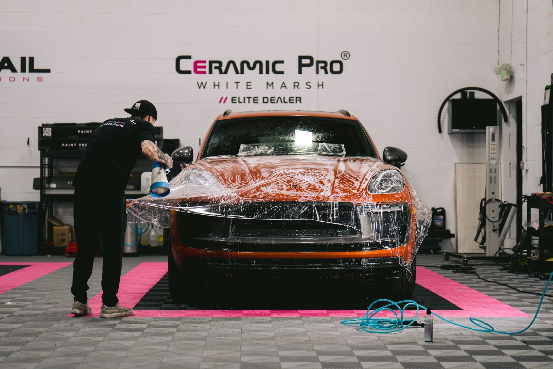 A man is washing a car in a garage.