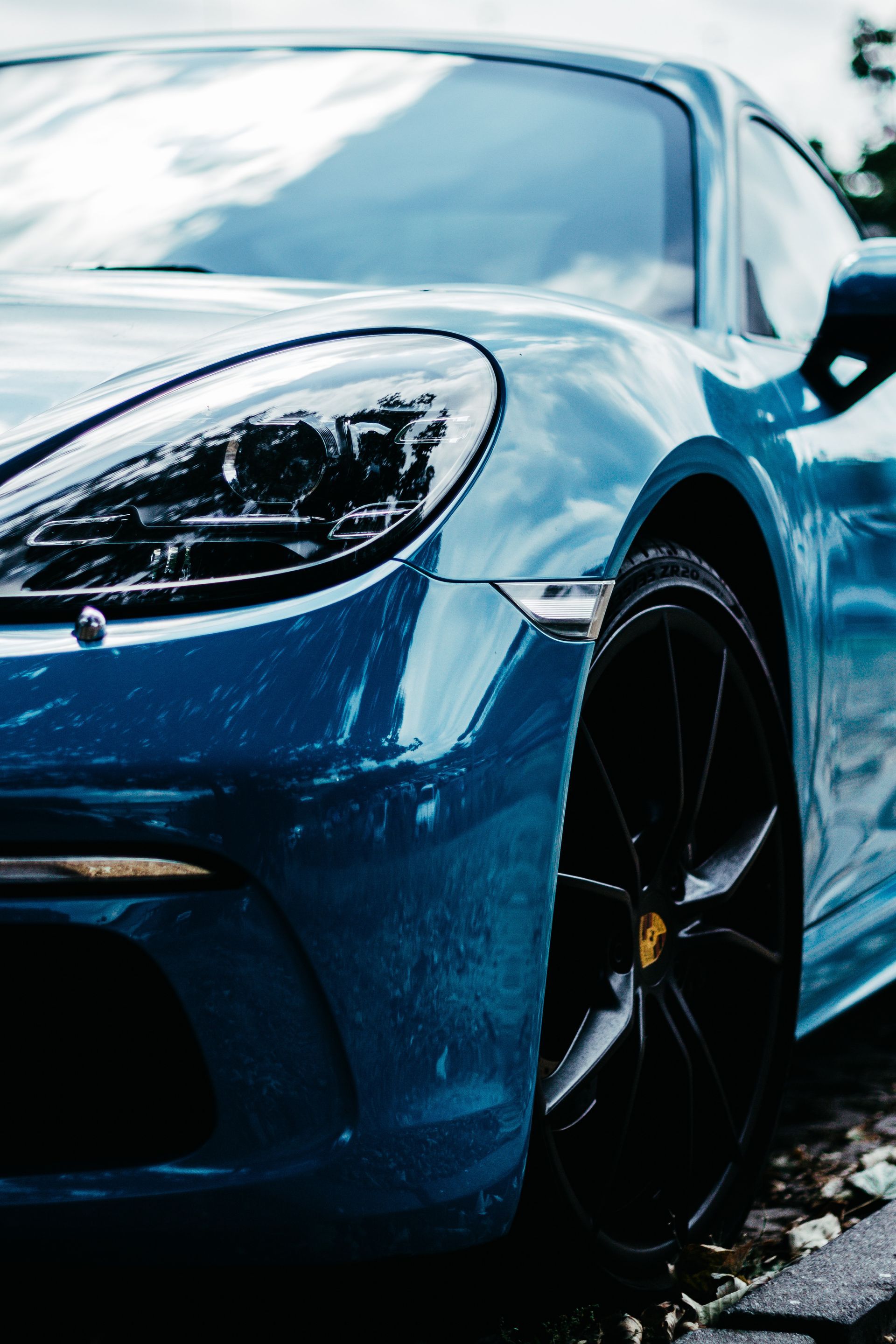 A blue sports car is parked on the side of the road.