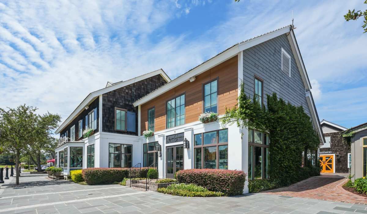 Exterior view of the apartment building with trees around at Reve Park Ridge in Little River, South Carolina