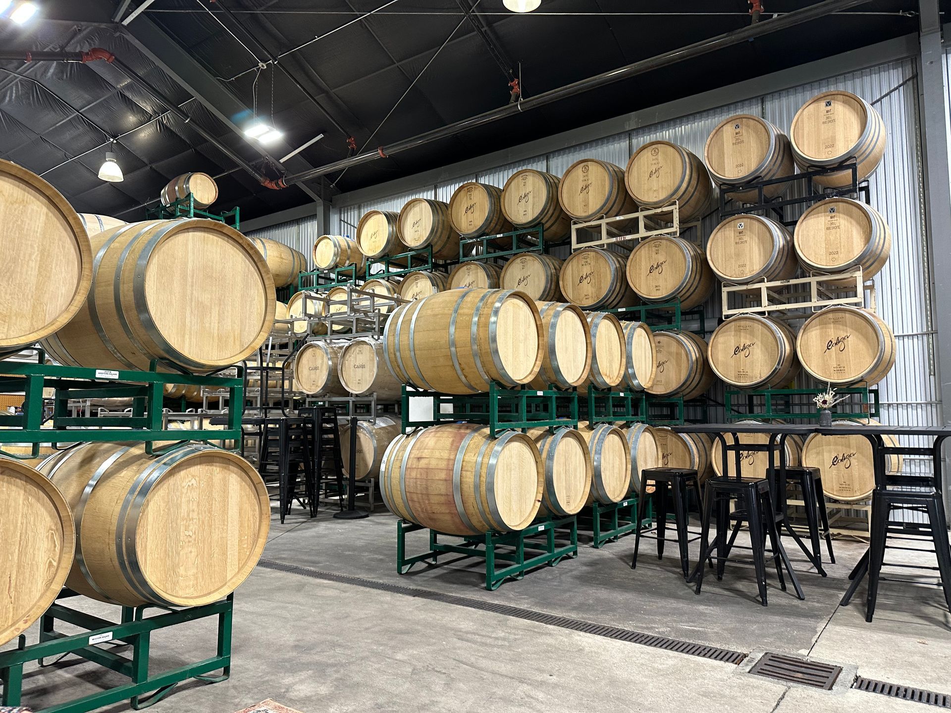 A warehouse filled with lots of wooden barrels stacked on top of each other.