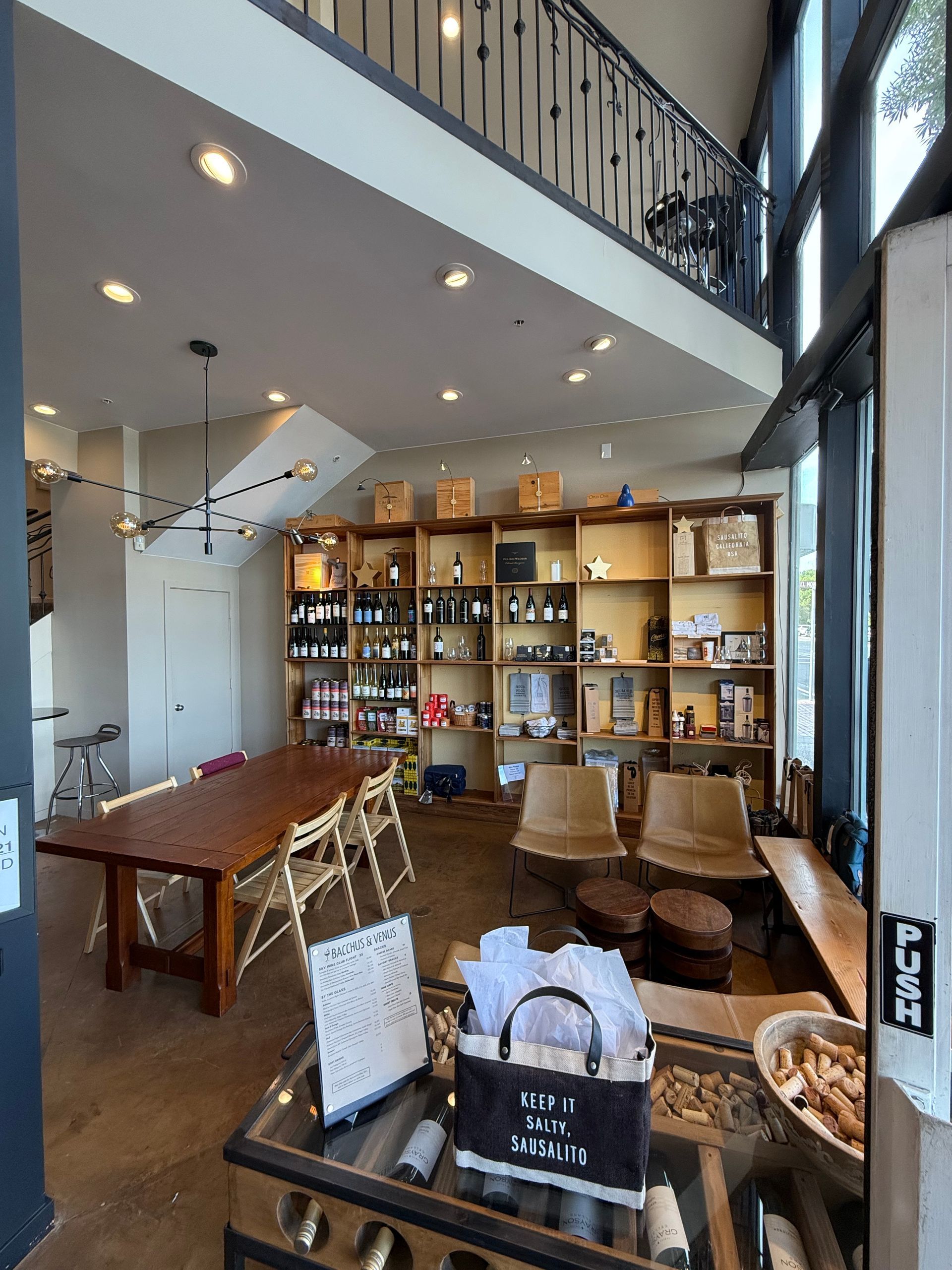 A living room with a table , chairs , shelves and a balcony.