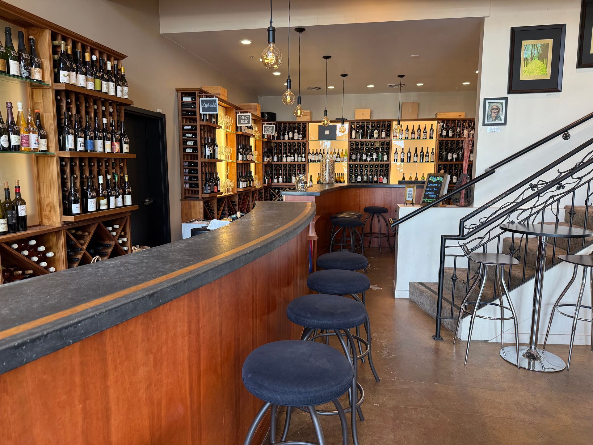 A row of wine bottles sitting on top of each other on a shelf.