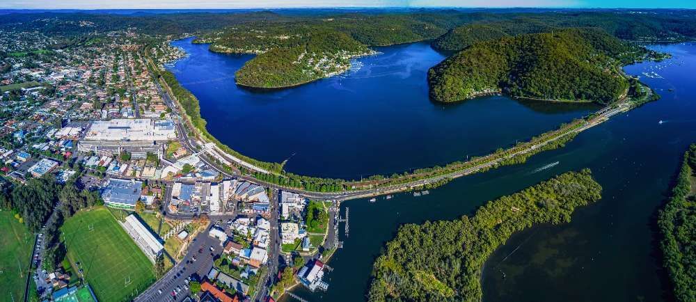 An Aerial View Of A Large Body Of Water Surrounded By Mountains And Trees — ASAP Pest Control in Brisbane South, QLD