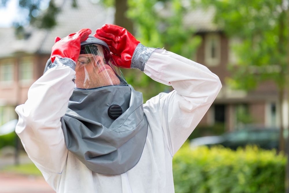 A Man Wearing A Protective Suit And Red Gloves Is Taking A Picture Of Himself — ASAP Pest Control in Mount Gravatt East, QLD