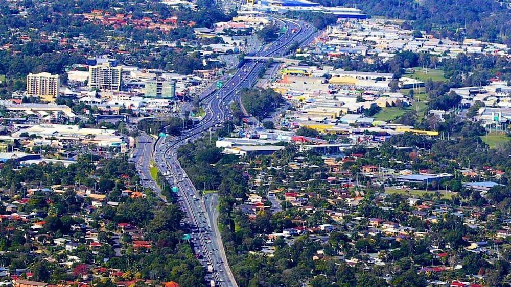 An Aerial View Of A City With A Highway Going Through It — ASAP Pest Control in Logan, QLD