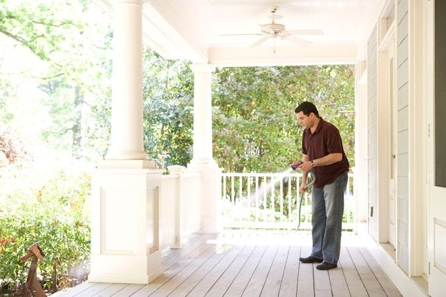 A Man Is Standing On A Porch Looking At Something — ASAP Pest Control in Mount Gravatt, QLD