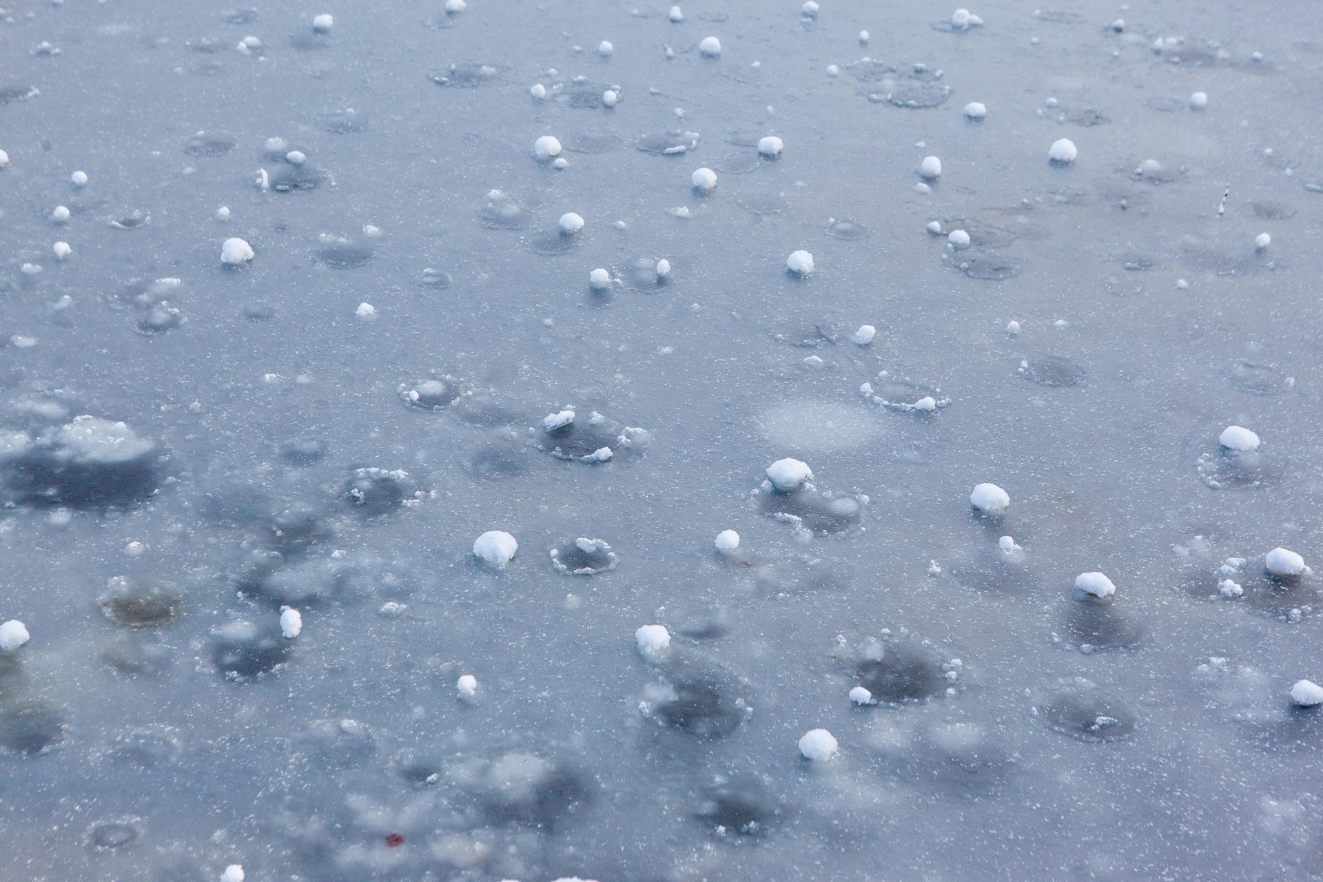 A close up of a gray surface with white balls on it.
