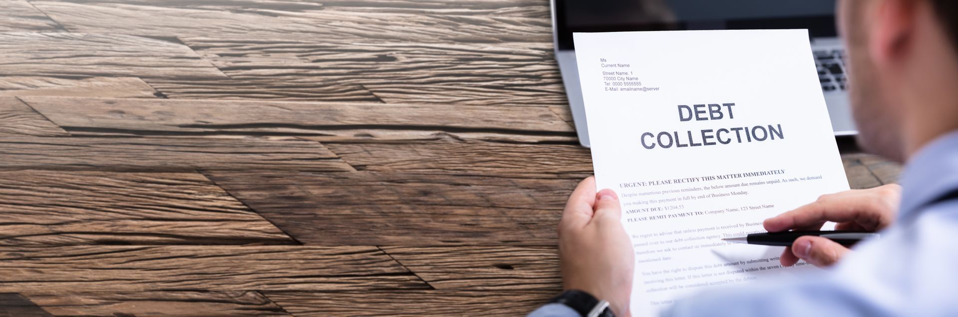 Experienced debt collector reviewing legal paperwork for debt collection.