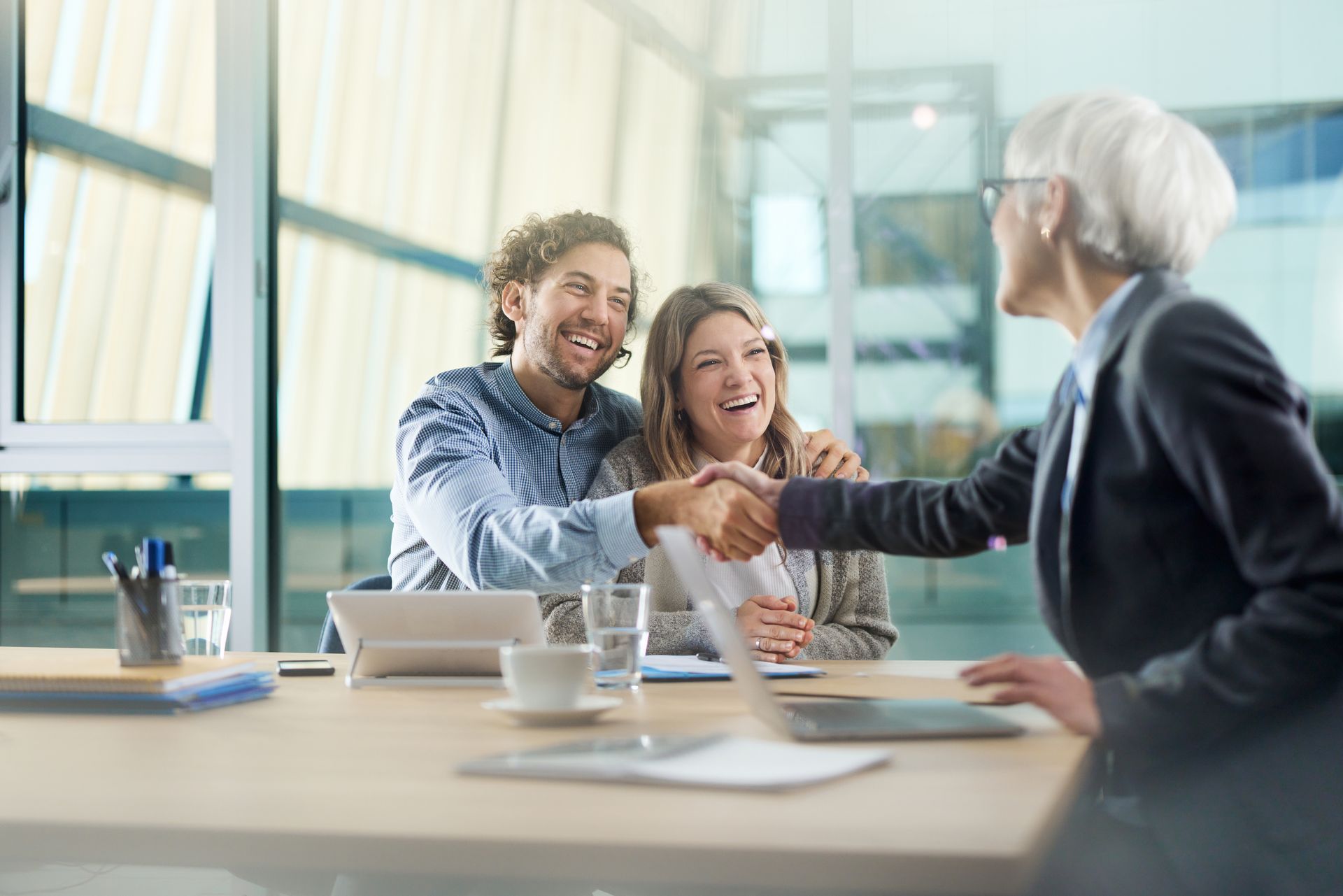A Man And Woman Shaking Hands With A Woman In A Suit — Savannah, GA — Abercorn Insurance Agency