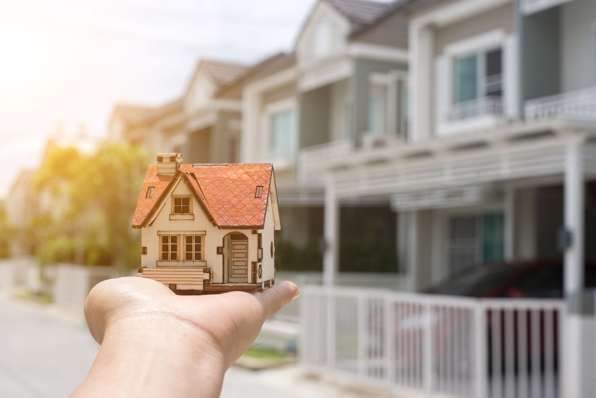 A Person Holding A Small Model House With A Red Roof — Savannah, GA — Abercorn Insurance Agency