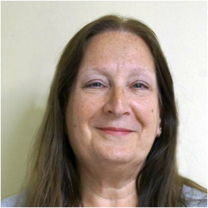 A woman with long hair is smiling for the camera.