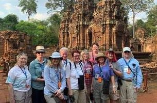 A group of people are posing for a picture in front of a temple.