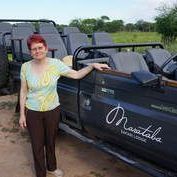 diane blair hickey A woman is standing next to a jeep in a field.
