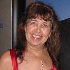 A woman in a red dress is smiling for the camera.