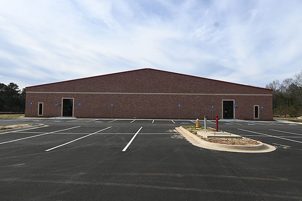 A large brick building with a parking lot in front of it.