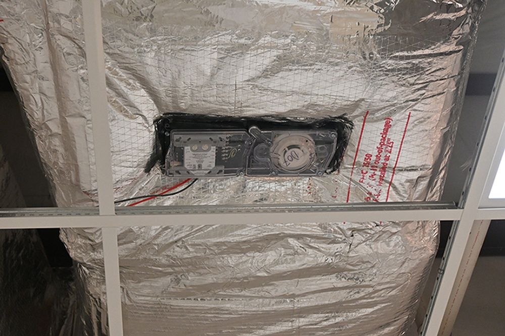 A ceiling with aluminum foil covering it and a fan.