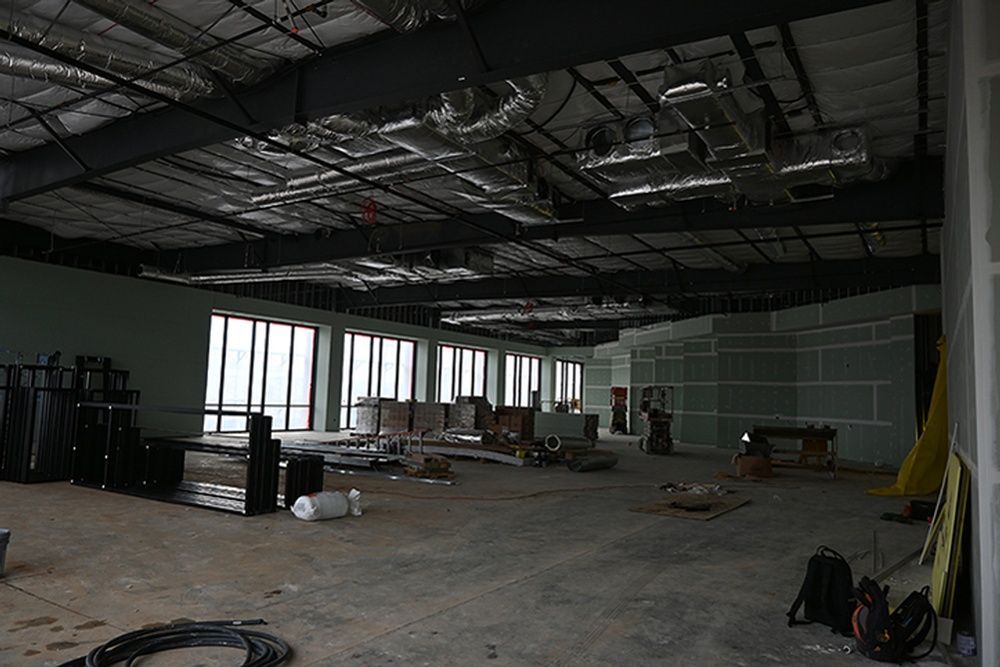 A large empty room with a lot of windows is being built.
