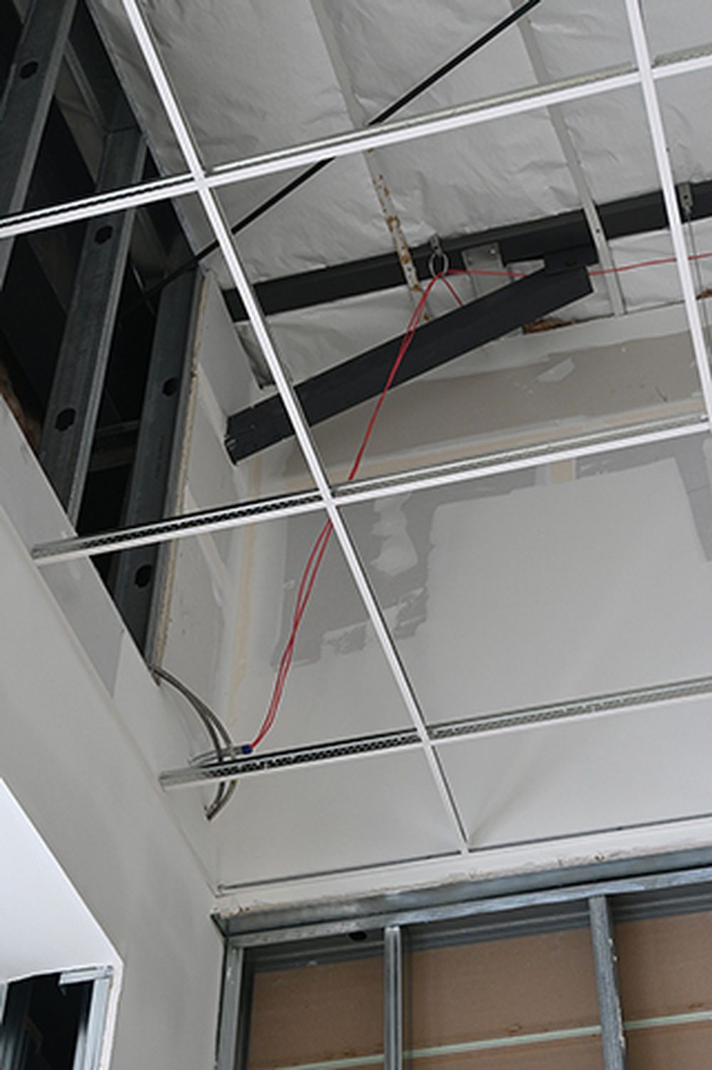 A ceiling with a lot of wires hanging from it.