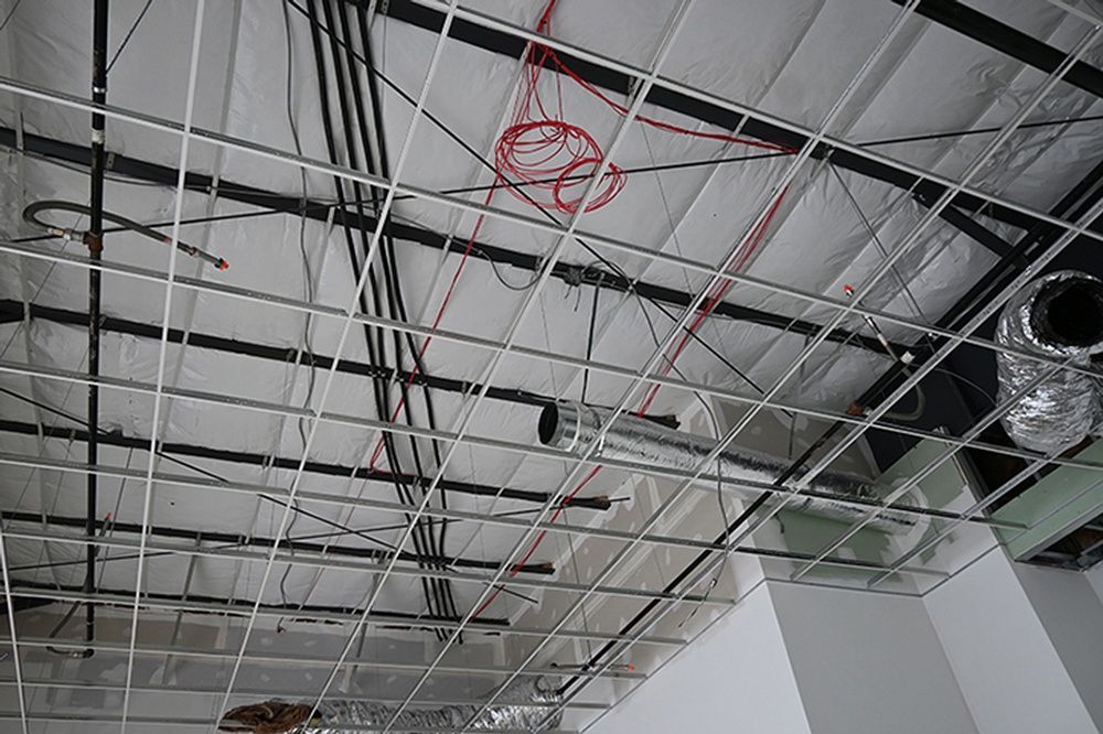 A ceiling with a lot of wires hanging from it.