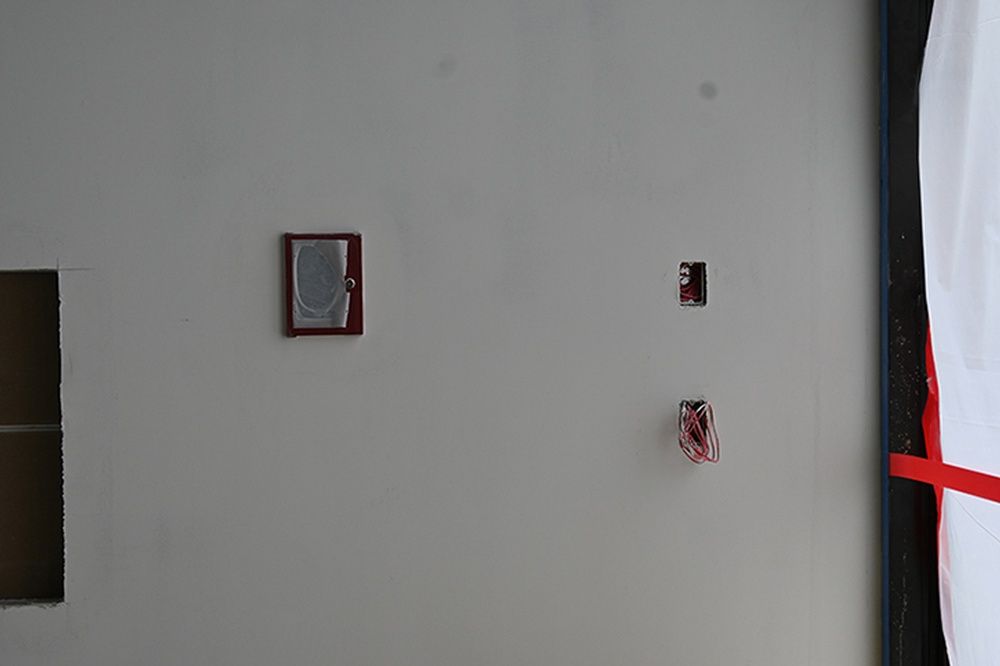 A white wall with a few pieces of art on it.