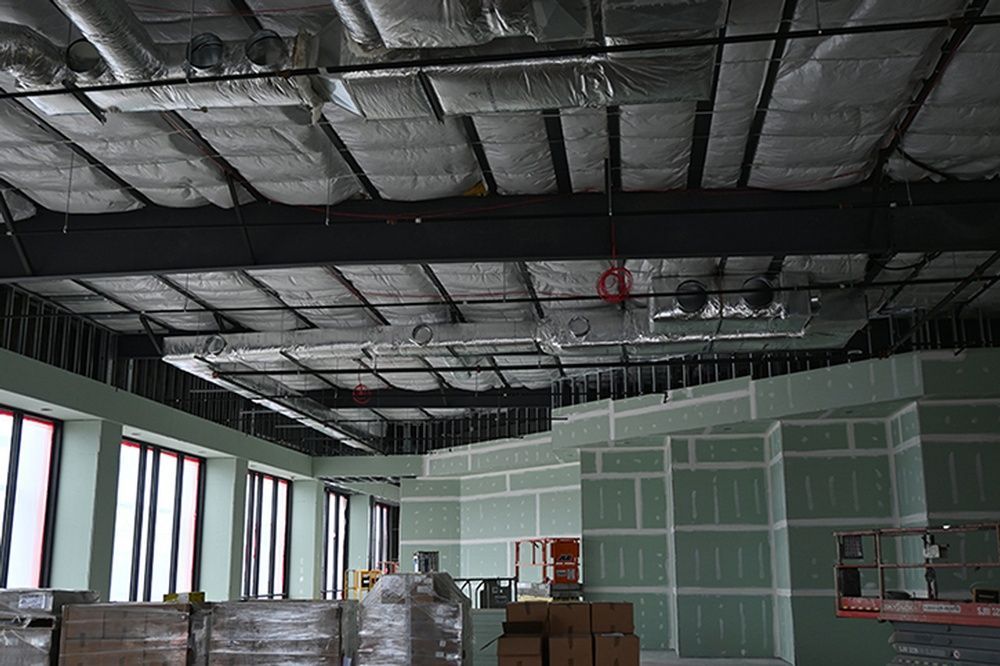 A large room with a ceiling that is being built and a lot of windows.