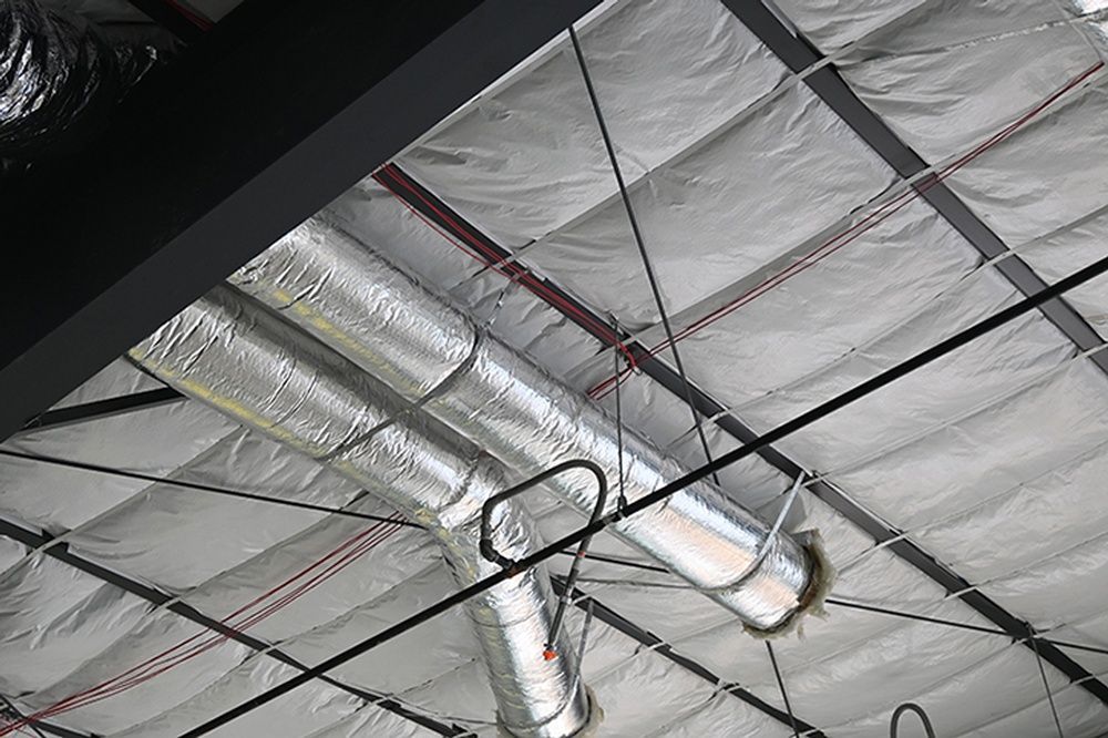 A ceiling with a lot of pipes hanging from it.