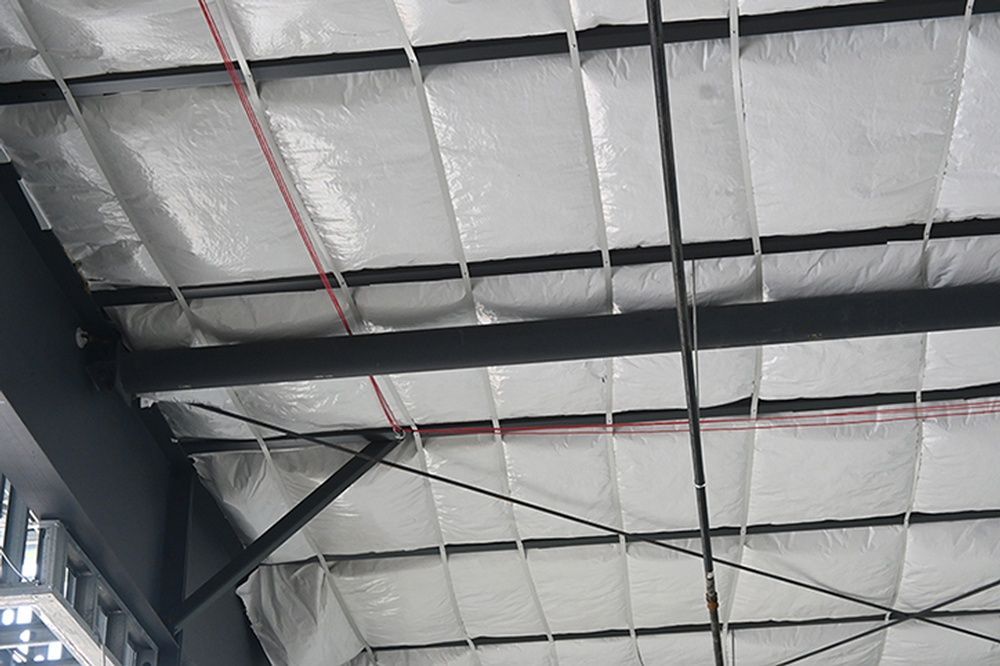 The ceiling of a building with a lot of insulation on it.