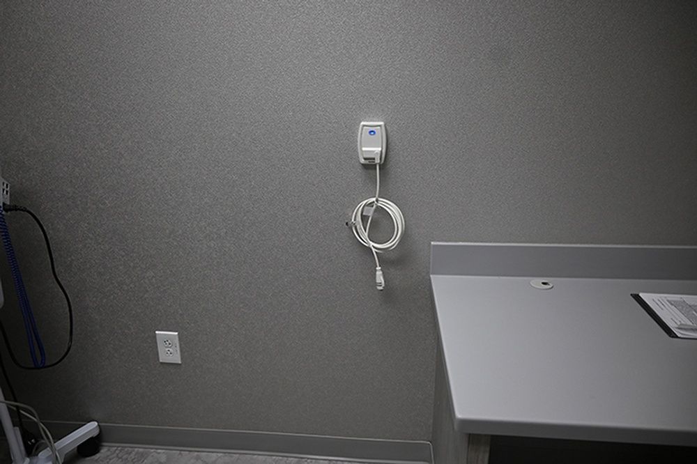 An empty room with a table and a cord hanging from the wall.